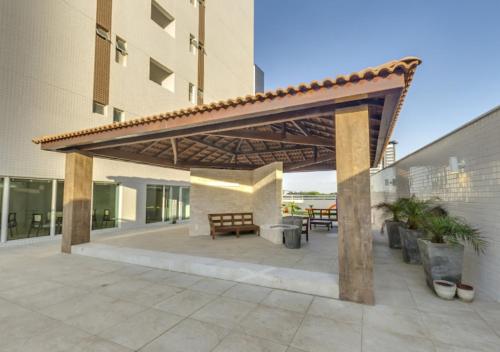 a wooden pergola on a patio in front of a building at Conforto Na Melhor Localização Com Vista Mar in São Luís