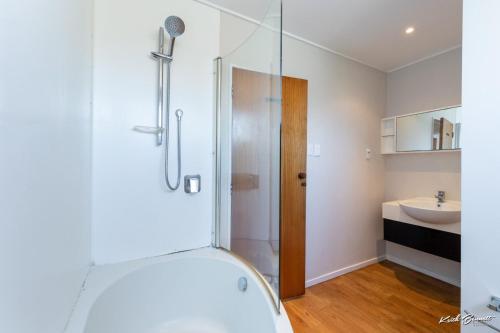 a bathroom with a shower and a sink at 5 bedroom modern house, private spacious backyard in Lower Hutt