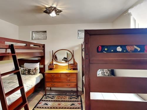 1 dormitorio con 2 literas y espejo en El Otro Tierra en Santa Fe