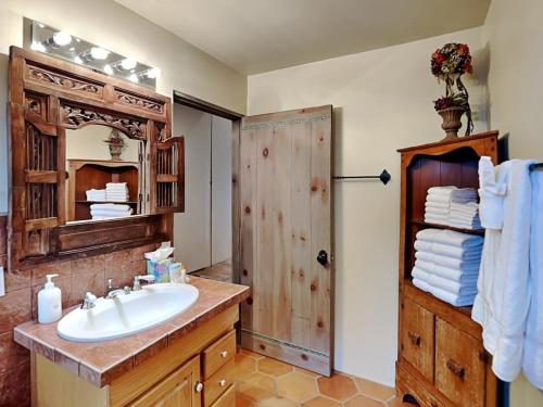 a bathroom with a sink and a shower with a mirror at El Otro Tierra in Santa Fe