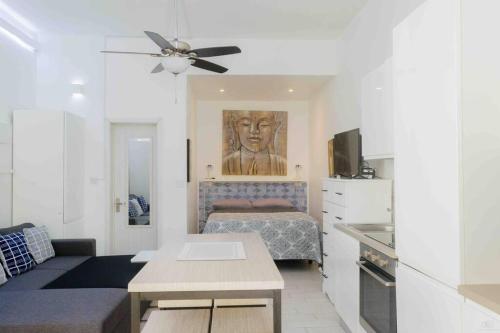 a living room with a bed and a ceiling fan at BBC Beach Condo in Morne Rouge