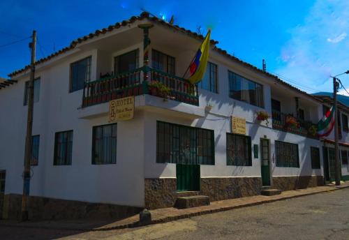 ein weißes Gebäude mit Flaggen auf der Seite in der Unterkunft Hotel Villa de Mongui in Monguí