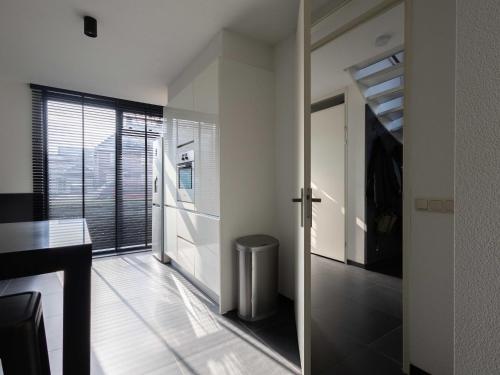 een hal met een deur naar een kamer met een raam bij Modern Ninety-One in Berghem