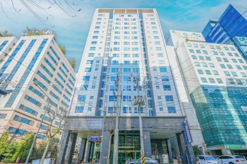 a tall white building with cars in front of it at 호텔 아벤트리 여의도 in Seoul