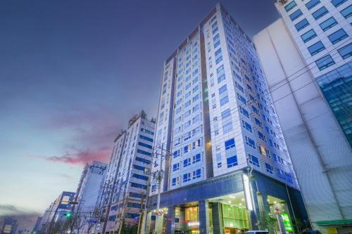 a tall building in a city with tall buildings at Hotel Aventree Yeouido in Seoul