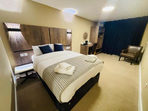 a bedroom with a large bed with towels on it at Hylands Hotel in Coventry