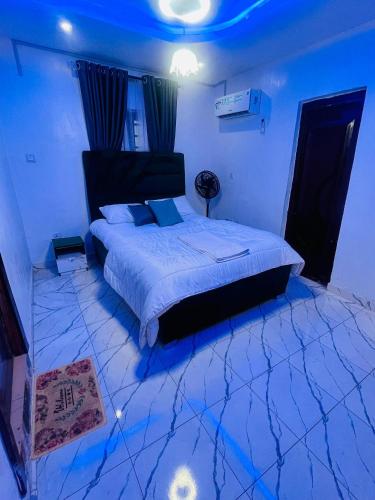 a bedroom with a large bed with blue lighting at Joel's Residence in Lagos