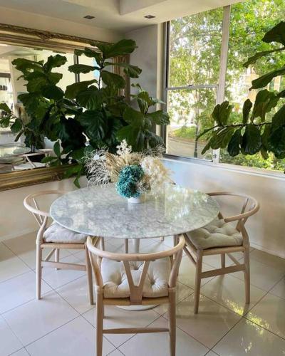 a dining room table with two chairs and a table with plants at Elizabeth Bay Marina Apartment in Sydney
