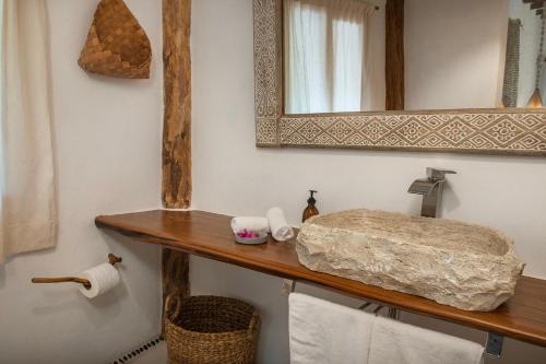 bagno con lavandino, specchio e asciugamani di Hotel Mawimbi a Isola Holbox