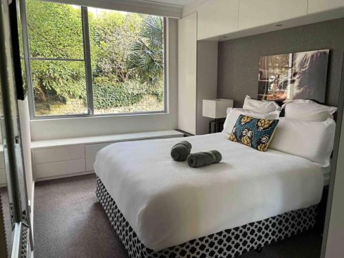 a bedroom with a large white bed with a large window at Elizabeth Bay Marina Apartment in Sydney