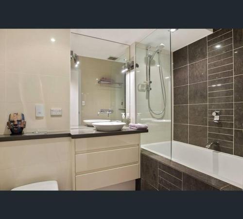 a bathroom with a toilet and a sink and a shower at Elizabeth Bay Marina Apartment in Sydney