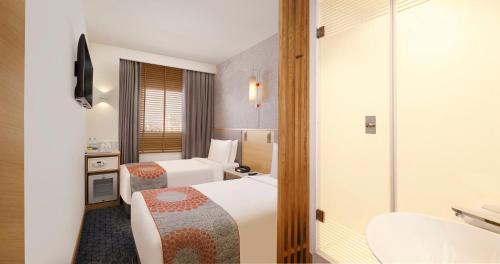 a hotel room with two beds and a bathroom at Holiday Inn Express Hyderabad HITEC City by IHG in Hyderabad