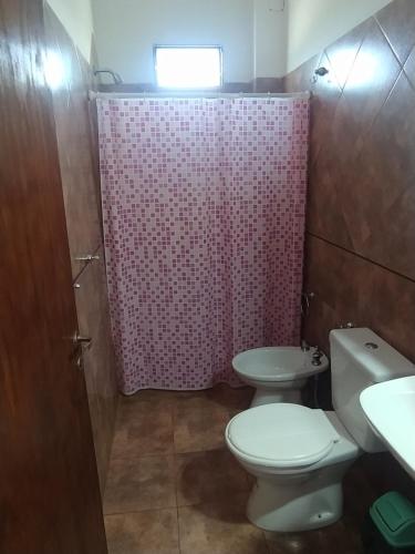 a bathroom with a toilet and a sink and a shower at Complejo LUMA in Villa Dolores