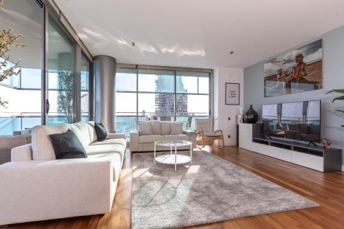 uma sala de estar com um sofá branco e uma mesa em Luxury Apartment With Sea View! em Barcelona