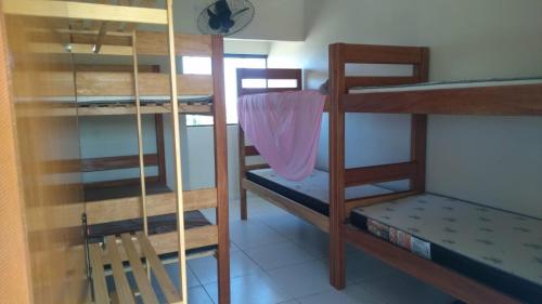 a room with three bunk beds and a ladder at Casa veraneio in Itamaracá
