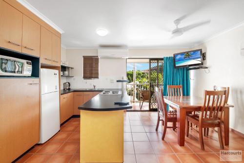 a kitchen and dining room with a table and chairs at Driftwood on the Beach in Yeppoon