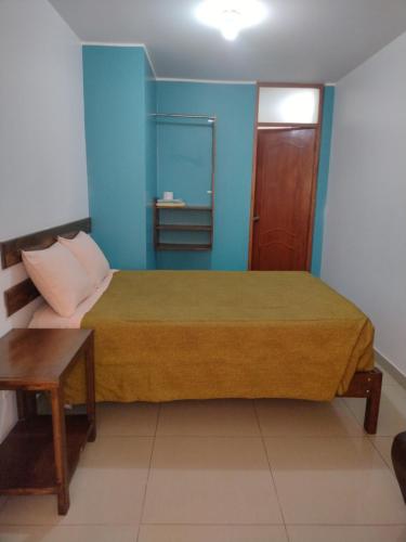 1 dormitorio con 1 cama con pared azul en HOSPEDAJE ICA, en Ica