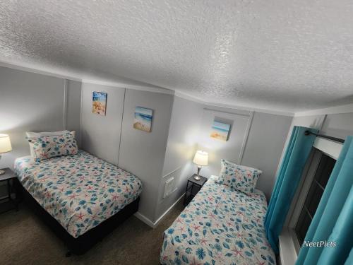 a room with two beds in a room with blue curtains at Inn at Arch Rock in Depoe Bay