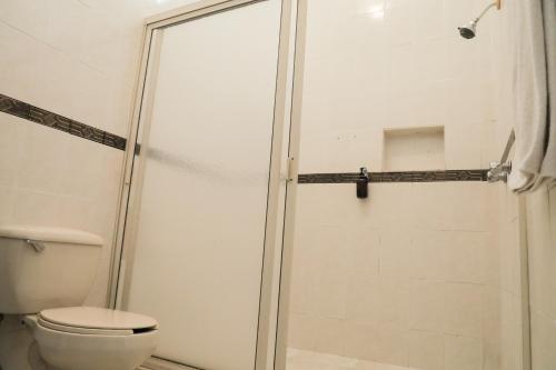 a shower stall in a bathroom with a toilet at ANTIQUE Guest House Fundidora in Monterrey