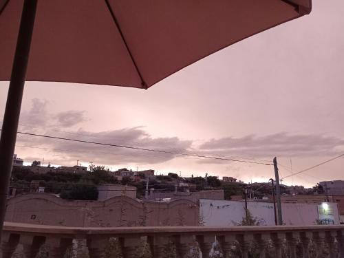 a view of a sunset from a balcony with an umbrella at VelayWasi in Humahuaca