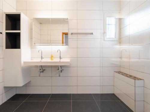 La salle de bains blanche est pourvue d'un lavabo et d'un miroir. dans l'établissement Tranquil holiday home with private pool, à Félines-Minervois