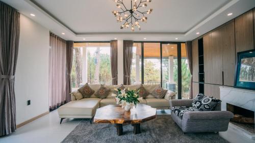 uma sala de estar com um sofá e uma mesa em Kim Ngan Hills Resort Da Lat. em Da Thien
