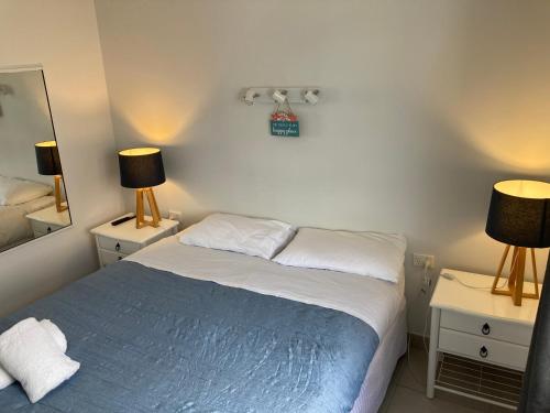 a bedroom with a bed and two lamps and a mirror at Driftwood on the Beach in Yeppoon