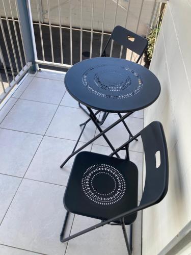 a table and a chair on a balcony at Driftwood on the Beach in Yeppoon