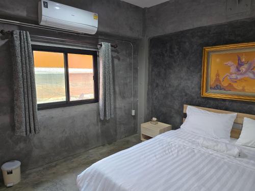 a bedroom with a white bed and a window at Captain Joe Cafe & Hostel in Hua Hin