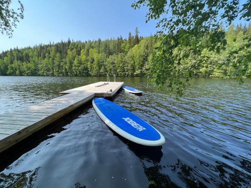 ein blaues Paddelbrett auf dem Wasser neben einem Dock in der Unterkunft Iken Mökit in Heinola