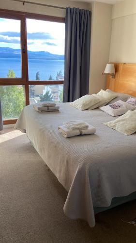 um quarto com uma cama grande com duas toalhas em Maqui Departamentos em San Carlos de Bariloche