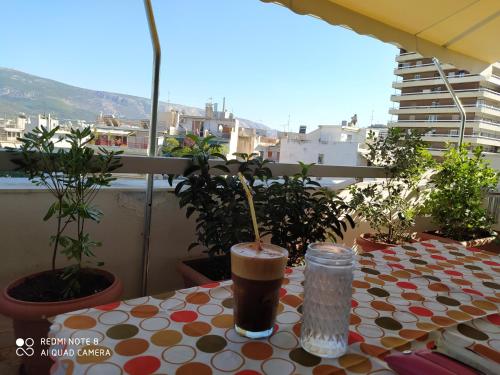 a table with a drink sitting on a balcony at Imittos View Apartment Athens Greece in Athens