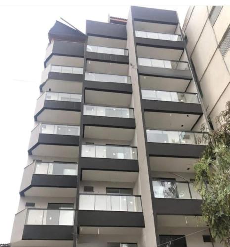 リオデジャネイロにあるAPT PEDRA DO PONTAL Recreioの窓がたくさんある高層アパートメントビル