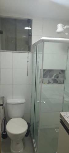 a bathroom with a toilet and a glass shower at APT PEDRA DO PONTAL Recreio in Rio de Janeiro