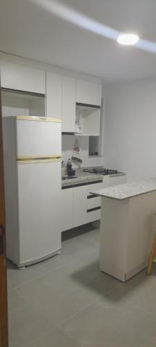 an empty kitchen with white cabinets and a counter at APT PEDRA DO PONTAL Recreio in Rio de Janeiro