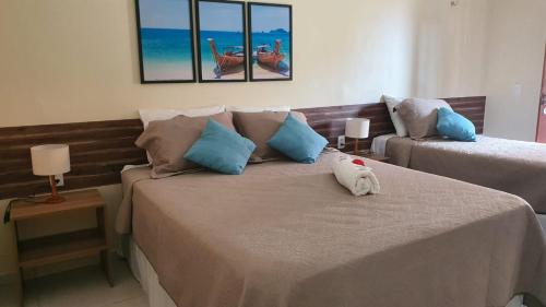 um quarto com 2 camas e almofadas azuis em Belladora Pousada em Barra Grande