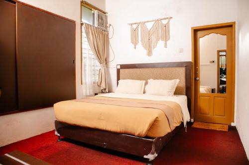 a bedroom with a large bed with a red carpet at Bamboosa in Bukittinggi