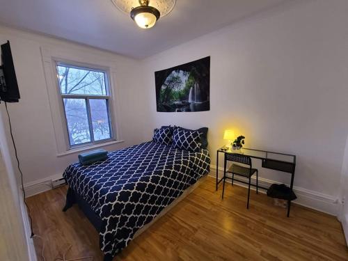 um quarto com uma cama, uma mesa e uma janela em Private Parking III Full Kitchen III Room B em Montréal