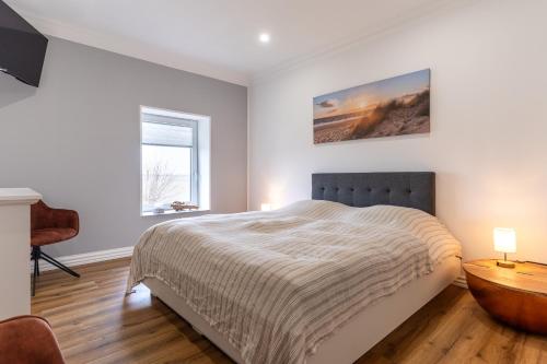 a bedroom with a bed and a desk and a window at Heimathafen an der Eider in Karolinenkoog