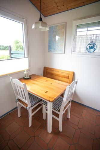 a wooden table and chairs in a room with a window at Lundenbergsand in Simonsberg