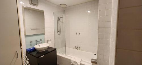 a bathroom with a sink and a tub and a shower at Centre Collins in Melbourne