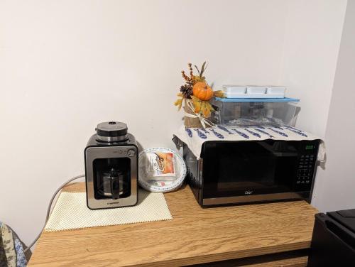 a microwave and a coffee maker on a table at Bright Room full of love and warmth in Bowmanville