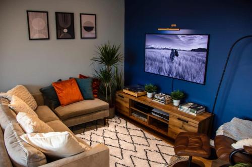 salon z kanapą i telewizorem z płaskim ekranem w obiekcie Cozy Urban Retreat in London w Londynie