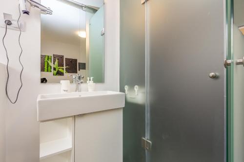 uma casa de banho com um lavatório e um chuveiro em Apartments with a swimming pool Pjescana Uvala, Pula - 22778 em Pula