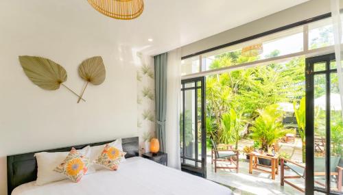 ein Schlafzimmer mit einem Bett und einem großen Fenster in der Unterkunft Luna Verde Hotel Hoi An in Hoi An