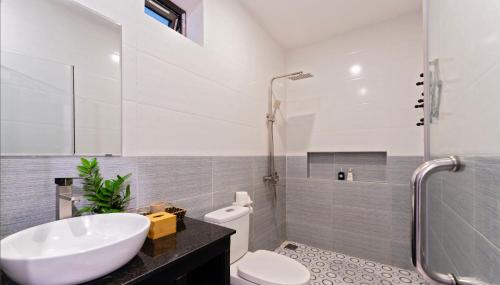ein Bad mit einem Waschbecken, einem WC und einer Dusche in der Unterkunft Luna Verde Hotel Hoi An in Hoi An