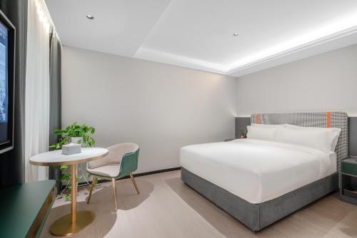 a bedroom with a bed and a table and a chair at R Royalss Hotel, Chengdu Chunxi Road Taikooli Tianfu in Chengdu