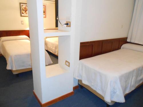 Zimmer mit 2 Betten und einem Spiegel in der Unterkunft Hotel Monterrey in Termas de Río Hondo