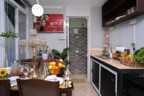 a kitchen with a table with a bowl of fruit on it at Golden V Grandeuria Unit E in Malolos