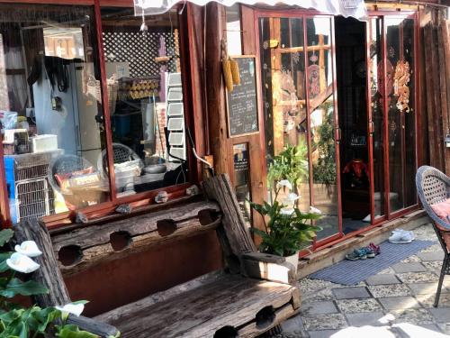 a wooden bench sitting in front of a store at Lijiang Jayden Lodge臣安山居民宿 - Namaste in Lijiang